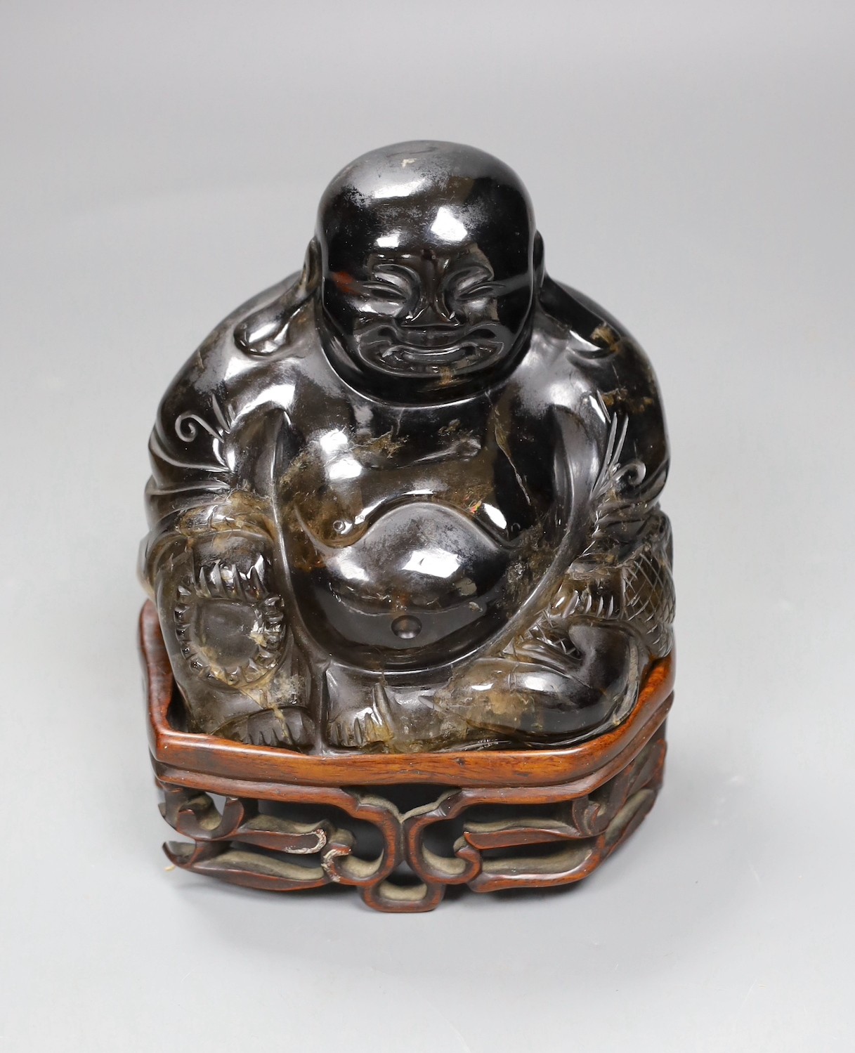 A large Chinese smoky quartz figure of Budai, 17cm tall including wood stand